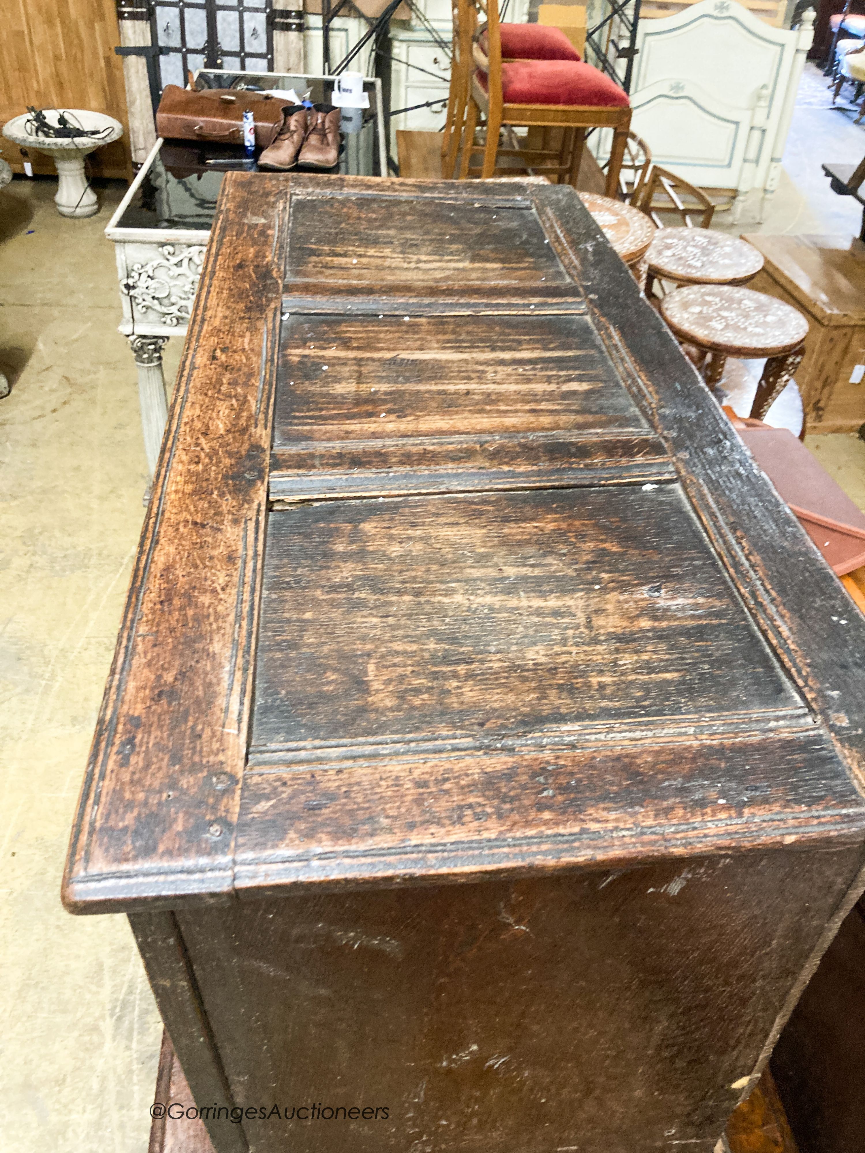 A 17th century caved panelled oak coffer, W.110cm D.48cm H.67cm